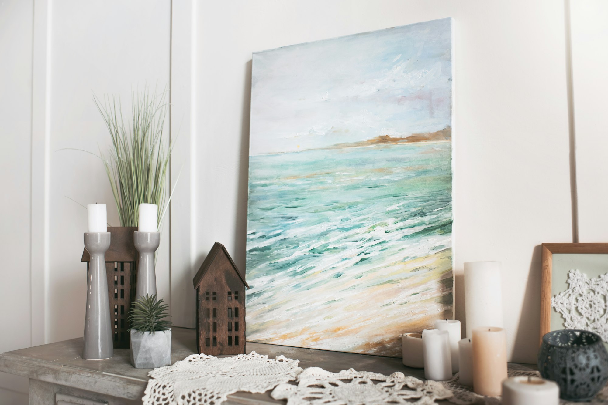 Picture of sea, candles and decorations standing on the shelf at home