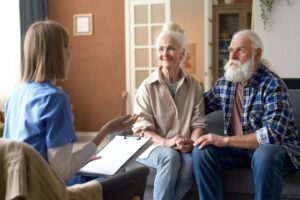 Nurse taking to senior couple at home