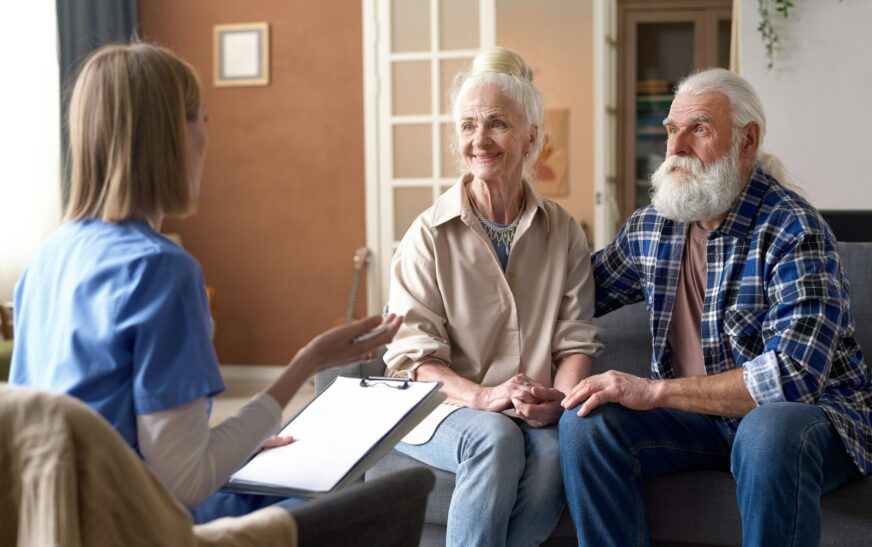 Nurse taking to senior couple at home