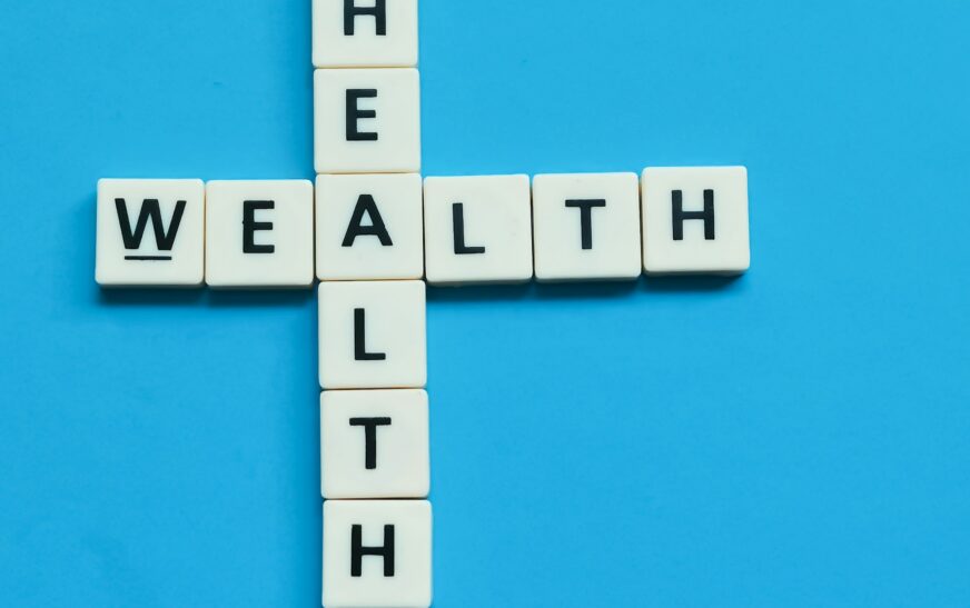 Wealth health word made from crossword square letter tiles on blue background.