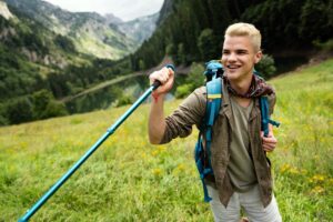 Young man traveling with backpack hiking in mountains