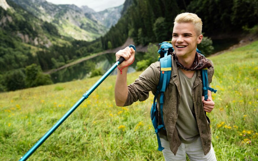 Young man traveling with backpack hiking in mountains